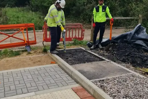 Two trainees reinstating a footway beside block paving and tactile slabs